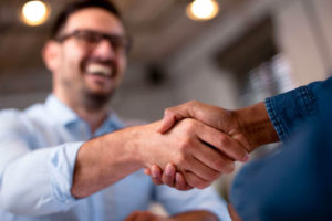 close up of person smiling and shaking hands with doctor