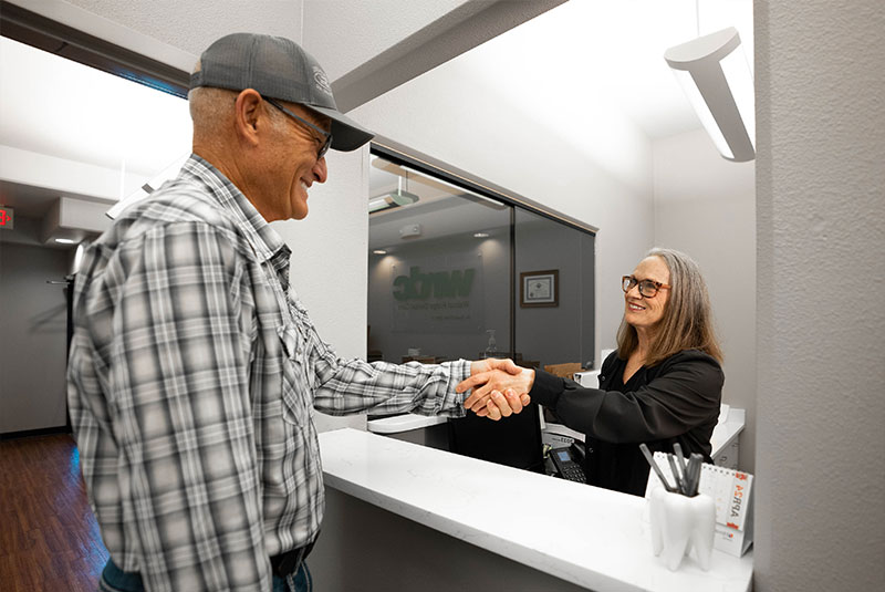 patient being help at the front desk of the dental center by staff member