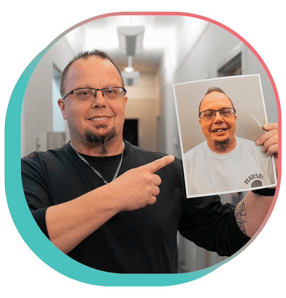 Patient smiling brightly while holding up their before procedure image