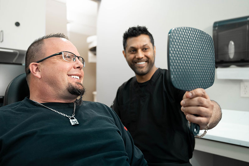 patient and doctor both smiling brightly after patient's dental procedure